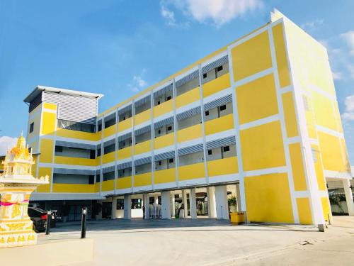 a yellow and white building with a yellow at Jarat Mansion in Surin