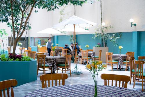 un restaurant avec des tables et des chaises et des personnes en arrière-plan dans l'établissement Hotel San Francisco, à Toluca