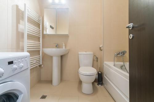 a small bathroom with a toilet and a sink at Orange Onix Apartaments in Bucharest