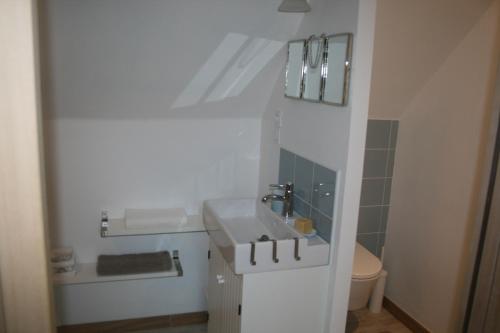 a white bathroom with a sink and a toilet at Les gites d'Hellen in Logonna-Daoulas