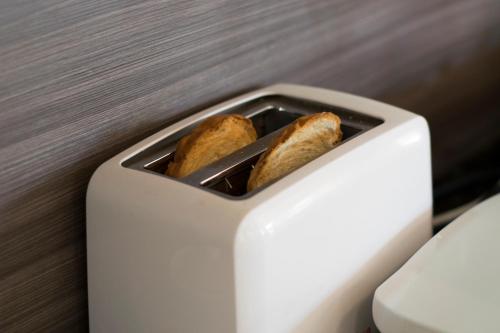two pieces of bread in a white toaster at Müller Hotel in Bella Vista