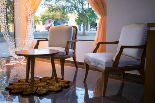 two chairs and a table in a room with a window at Müller Hotel in Bella Vista