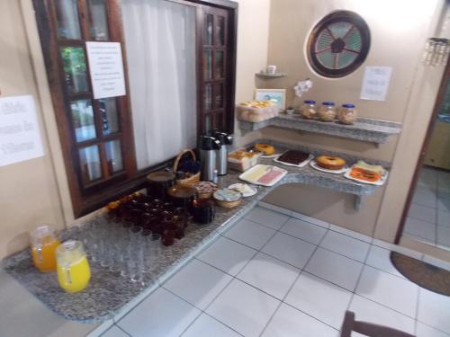 a counter with a bunch of food and drinks at Pousada Paraíso in Ilha do Mel