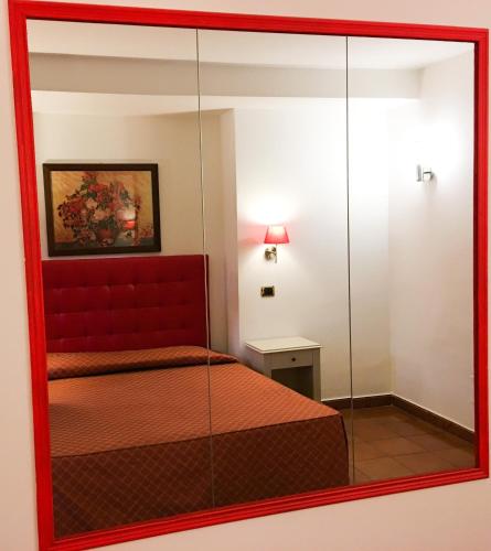 a mirror reflection of a bedroom with a bed in a room at Hotel Quadrifoglio Roma Eur in Mostacciano 