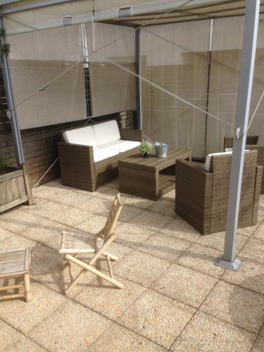 a patio with a chair and a couch and a table at Appartement ,superbe terrasse 40m2 , vieux Lille , centre ville in Lille