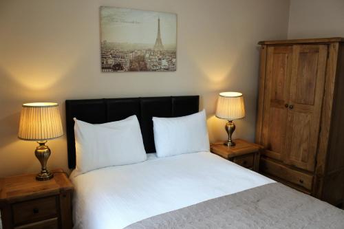 a bedroom with a bed with two lamps on tables at Wild Atlantic Accommodation 68 Burnside Park in Letterkenny