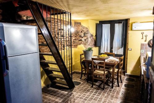 a kitchen and dining room with a table and a refrigerator at Cerami15 in Catania