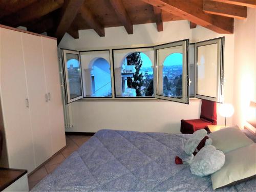 a bedroom with a bed and large windows at Appartamenti Esmera in Desenzano del Garda