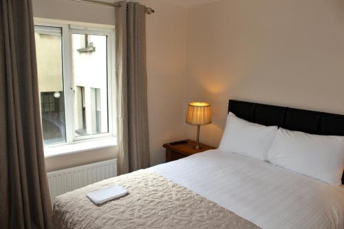 a bedroom with a bed and a window at Wild Atlantic Accommodation 2G Orchard Crescent in Letterkenny