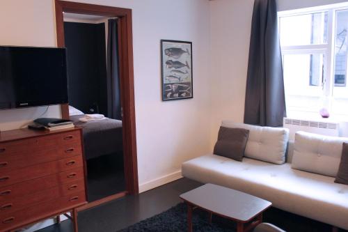 een hotelkamer met een bank en een spiegel bij Astro Apartments in Reykjavík