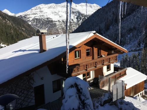 a building covered in snow with mountains in the background at Alpenspirit in Sölden