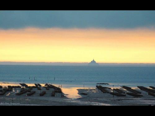 a beach with a group of boats in the water at La Capitainerie in Cancale