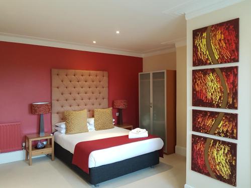 a bedroom with a bed with a red wall at The Relish in Folkestone