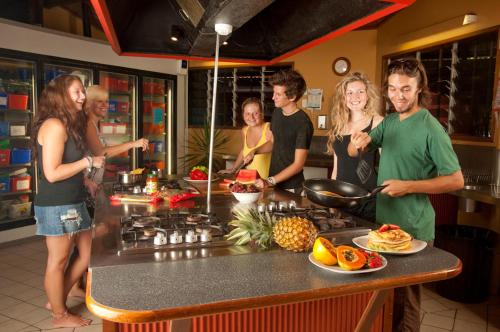 a group of people standing in a kitchen at Dougies Backpackers Resort in Port Douglas
