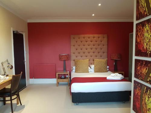 a bedroom with a bed and a red wall at The Relish in Folkestone