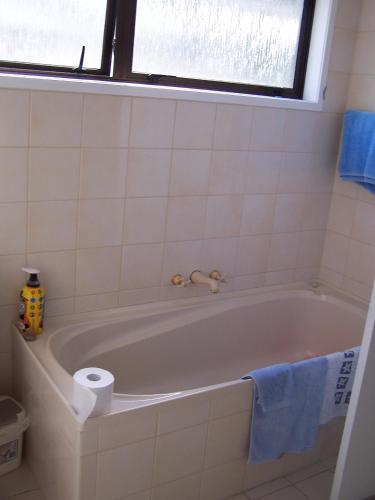 a bathroom with a tub with a roll of toilet paper at Austria Motel in Paihia
