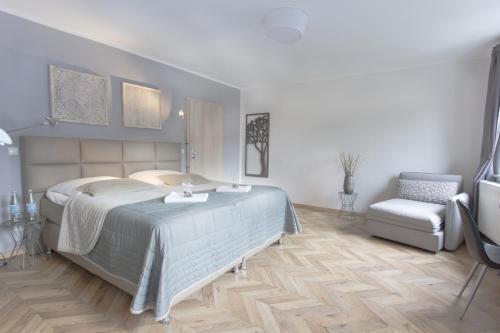 a bedroom with a large bed and a chair at TM Suites in Dortmund