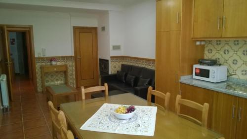 a kitchen with a table with a bowl of fruit on it at Casa das Neves in Ponte de Lima
