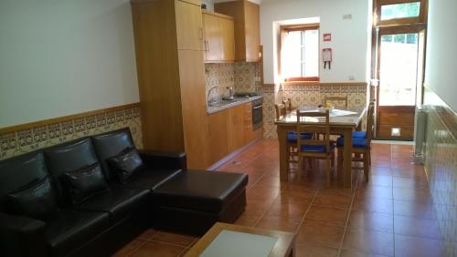 a living room with a couch and a table and a kitchen at Casa das Neves in Ponte de Lima