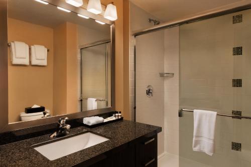 uma casa de banho com um lavatório e um chuveiro em Executive Inn Whistler em Whistler