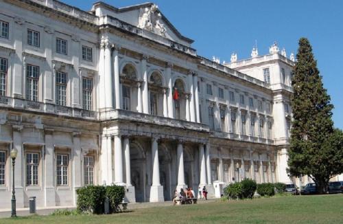 a large white building with people sitting outside of it at Belém Cozy Bedroom in Lisbon