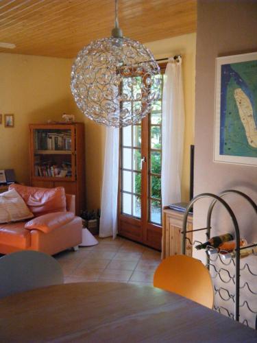 - un salon avec un lustre et un canapé dans l'établissement La maison d'été de mes parents, à Vendays-Montalivet