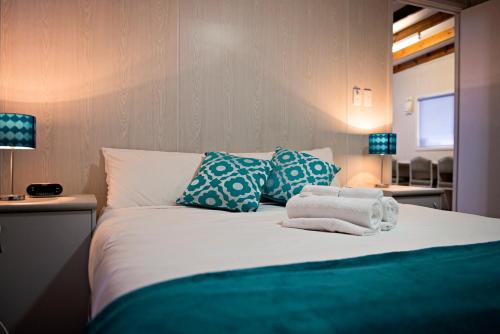 1 dormitorio con 1 cama con toallas en Rivergum Holiday Park, en Corowa