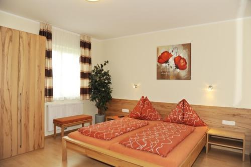 a bedroom with a bed with red pillows on it at Gasthaus Hotel Feldschlange in Ried im Innkreis