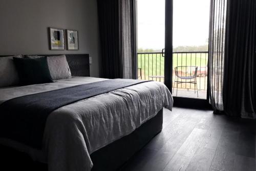 a bedroom with a bed with a view of a balcony at The Mitchelton Hotel Nagambie in Nagambie