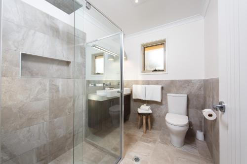 a bathroom with a shower and a toilet and a sink at Howlong Golf Resort in Howlong