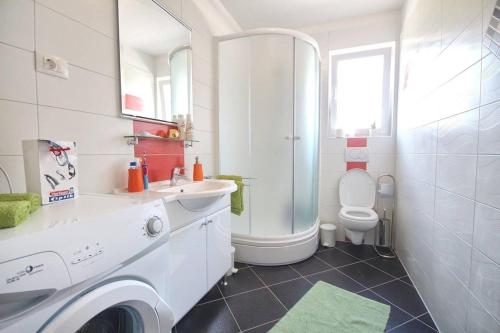 uma casa de banho branca com um lavatório e um WC em Apartment Borka em Medulin