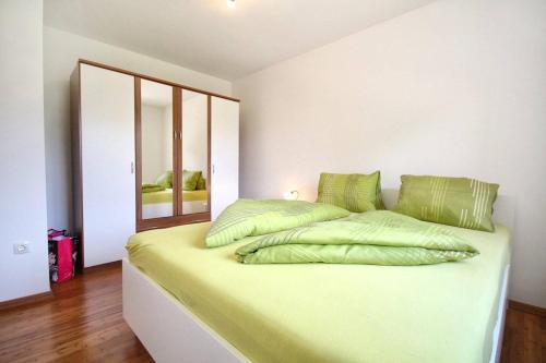 um quarto com uma cama grande e almofadas verdes em Apartment Borka em Medulin