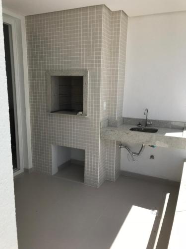 uma casa de banho com um lavatório e uma parede em azulejo em Apto Praia Ingleses 3q 2g em Florianópolis