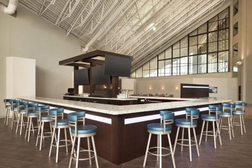 a large kitchen with a bar with blue stools at Holiday Inn - Bloomington - Normal by IHG in Normal
