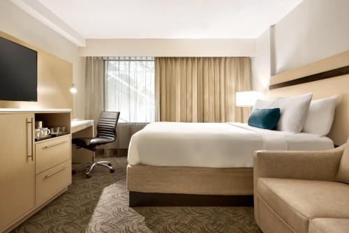 Habitación de hotel con cama grande y escritorio. en Holiday Inn - Bloomington - Normal, an IHG Hotel, en Normal