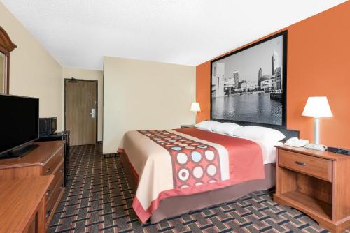 a hotel room with a bed and a flat screen tv at Super 8 by Wyndham Kent/Akron Area in Kent