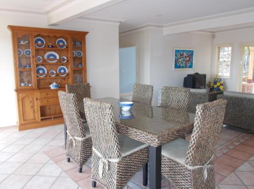 a dining room with a table and chairs at Tranquil Garden Hideaway in Ormeau