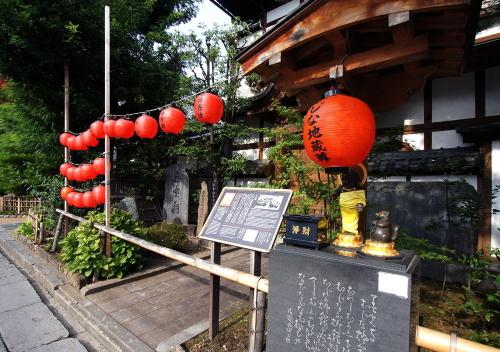 a shrine with red lanterns and a sign in front of a building at Hotel Trend Nagano in Nagano