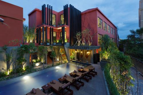 ein Haus mit einem Pool vor einem Gebäude in der Unterkunft Golden Temple Villa in Siem Reap