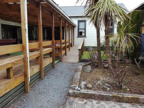 a porch of a house with a palm tree at Slalom Lodge in Raurimu Spiral