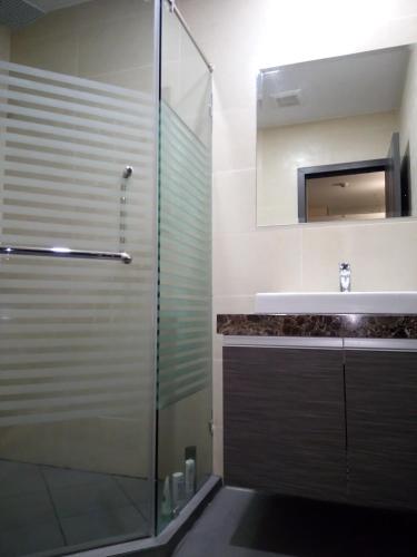 a bathroom with a glass shower and a sink at Dusit Grand Condo View in Jomtien Beach