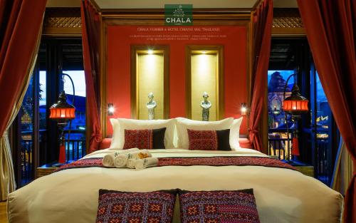 a bedroom with a large bed with red walls at Chala Number6 in Chiang Mai
