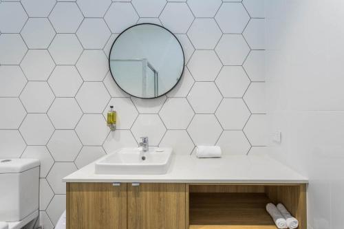 uma casa de banho com um lavatório e um espelho em Civic Apartments em Wagga Wagga