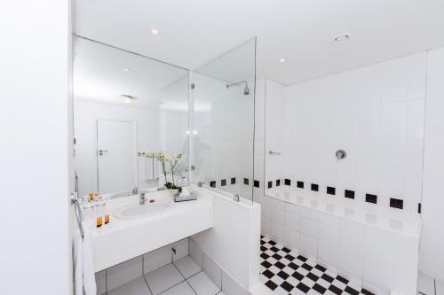 
a bathroom with a sink, mirror, and bath tub at The New Tulbagh Hotel in Cape Town

