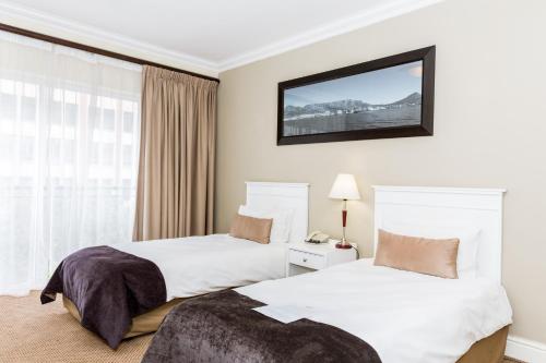 a hotel room with two beds and a window at Innscape Classic Hotel in Cape Town