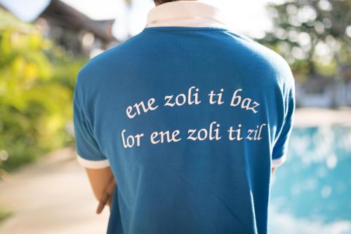 a person wearing a blue shirt that says one it day for one it at Toparadis Guest House in Pereybere
