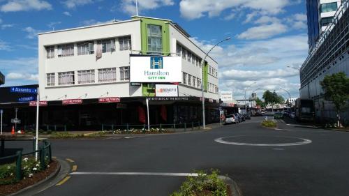 una calle con un edificio blanco al lado de una carretera en Hamilton City Inn en Hamilton