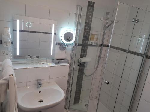 a bathroom with a sink and a glass shower at Hotel zum Anker in Andernach