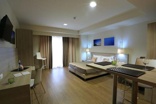 a hotel room with a bed and a desk in it at Turin Airport Hotel & Residence in San Francesco al Campo