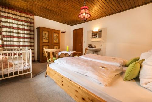 ザンクト・ガレンキルヒにあるAppartement Landhaus Einsiedlerのベッドルーム(ベッド2台、ベビーベッド1台付)